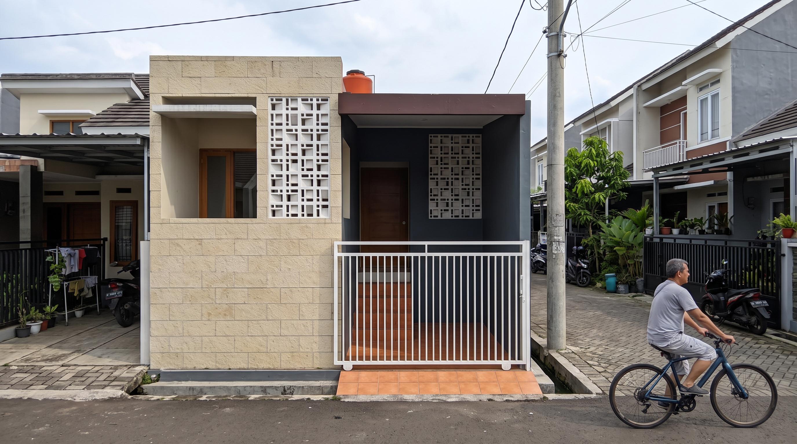 Rumah kompak modern dengan fasad batu alam paras krem dan roster di Mijen Semarang
